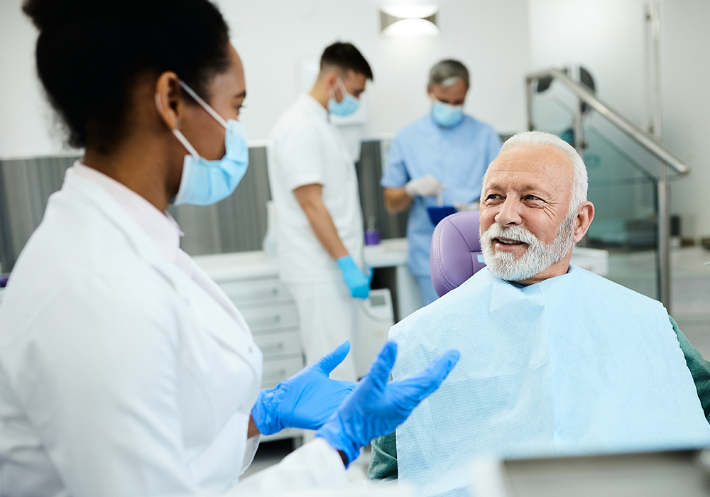 Elederly male speaking to a female dentist