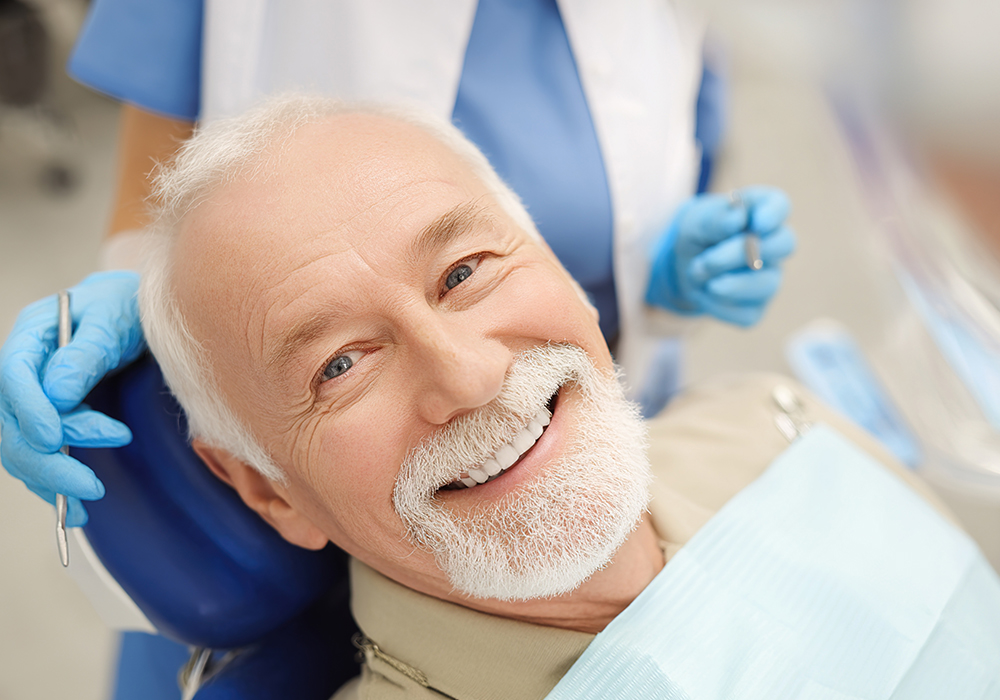 Elderly man smiling with dentures in place