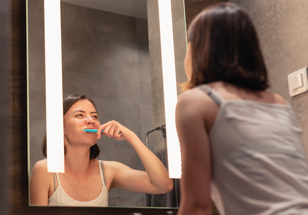 Woman brushing teeth at night