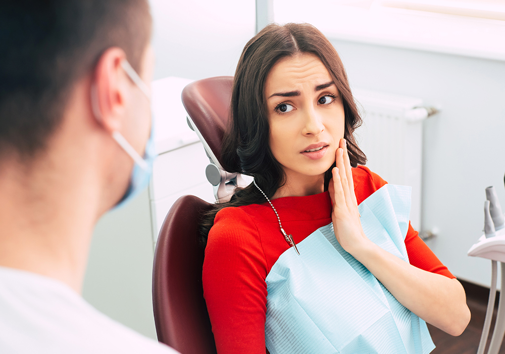 Woman speaking with dentist about tooth pain