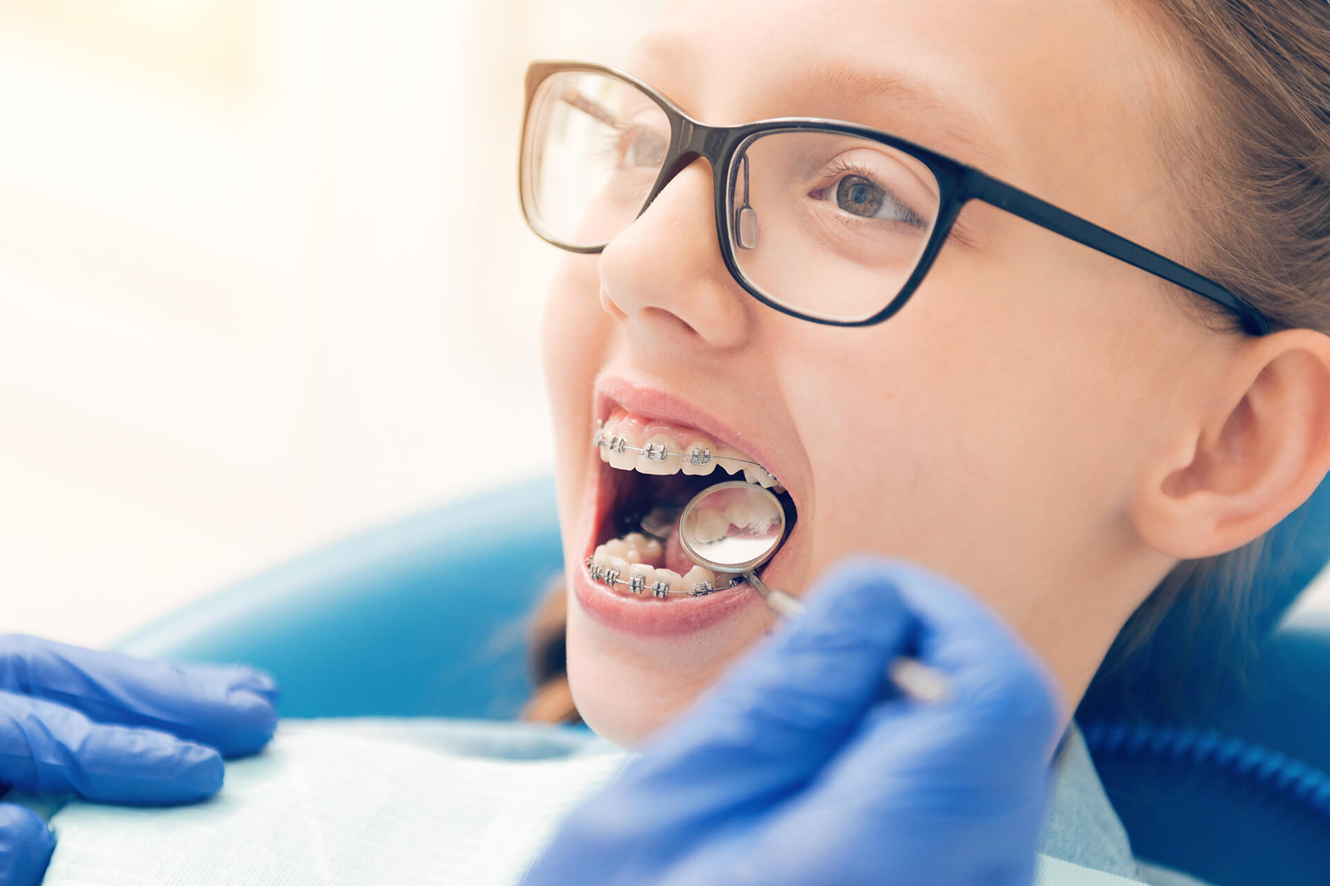 doctor inspecting teeth of young girl