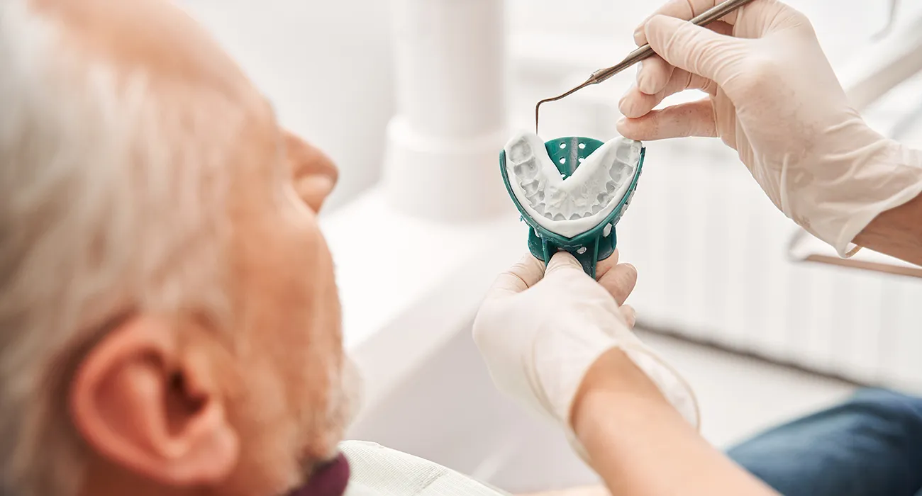 dentist doing impression of teeth for dentures
