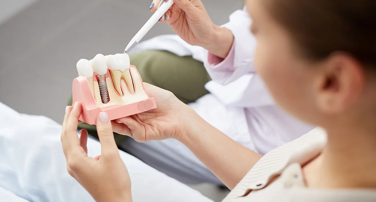 dentist showing patient display of implant