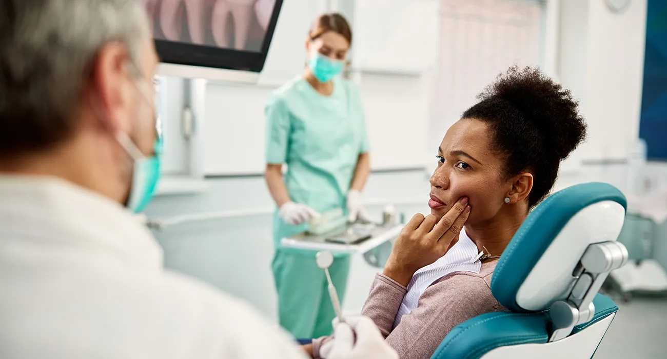 Woman holding her jaw due to dental pain