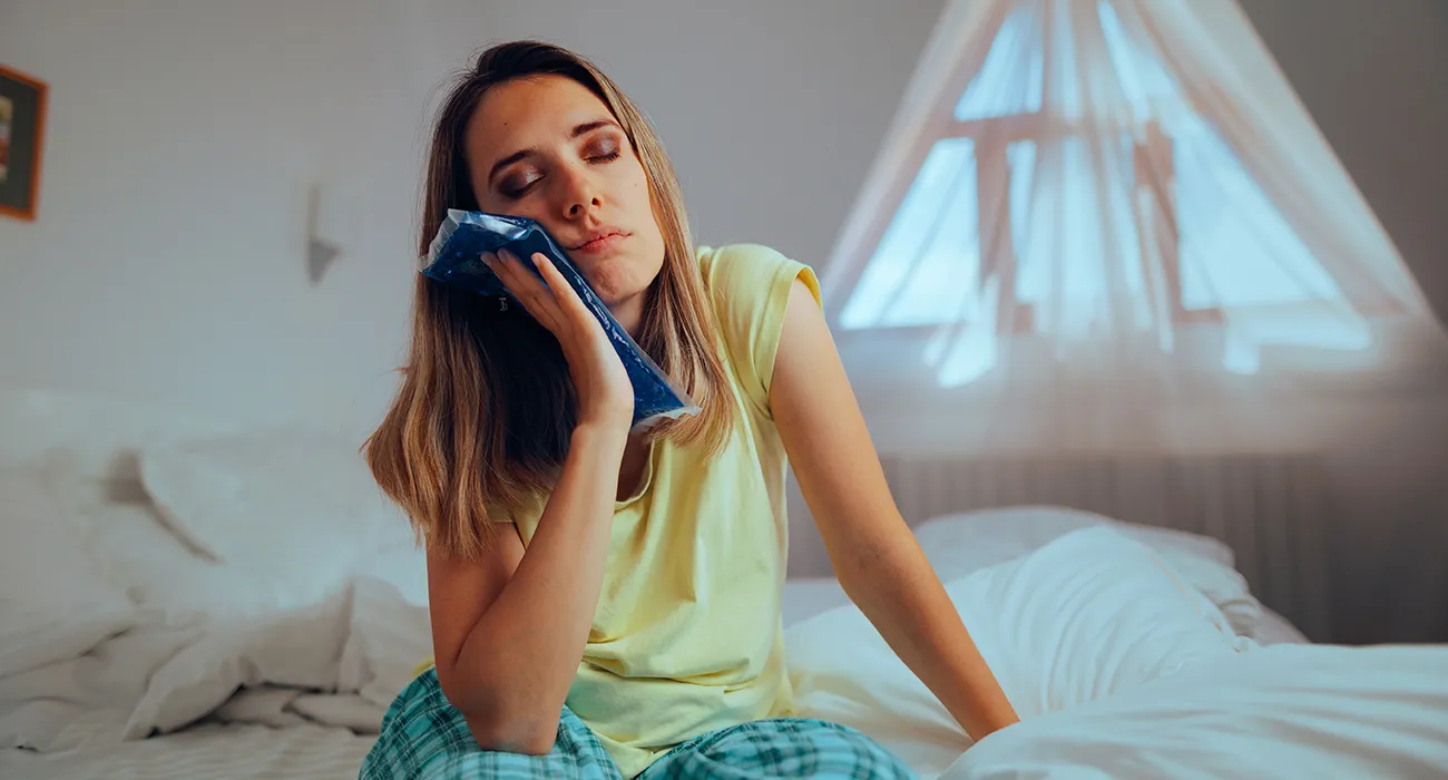 woman holding mouth in pain