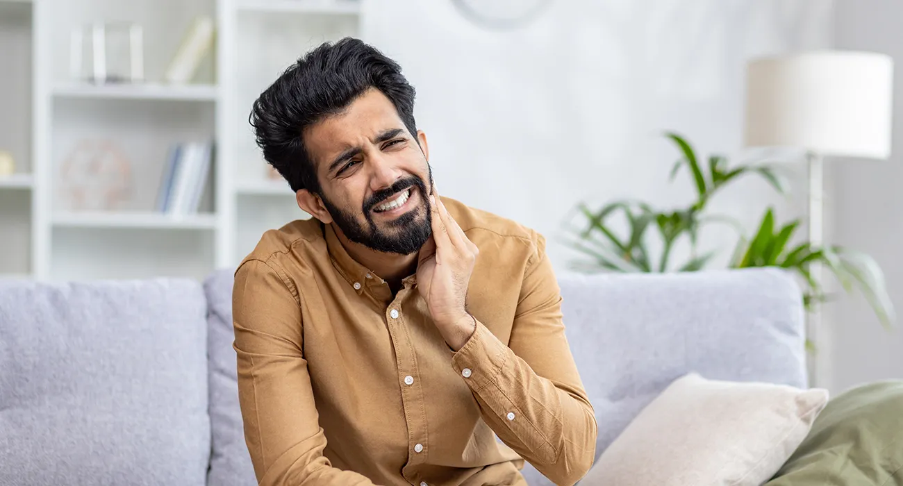 man holding mouth in pain