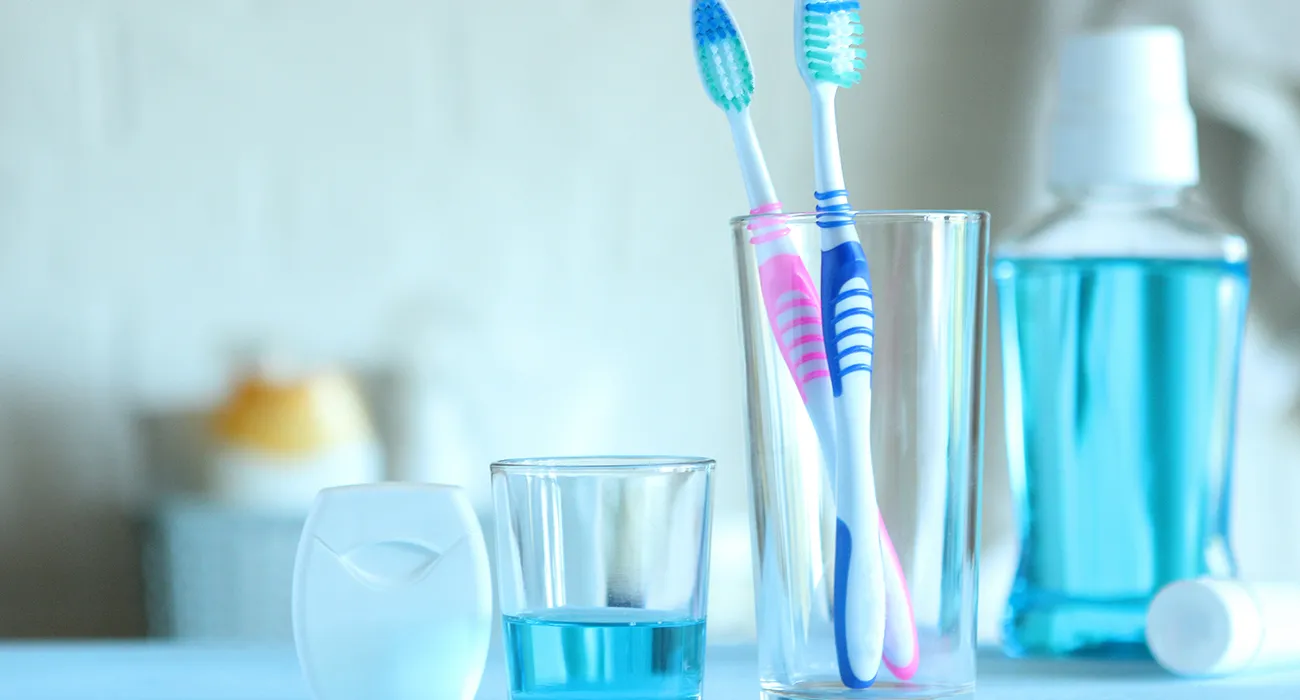 toothbrushes on counter in glass