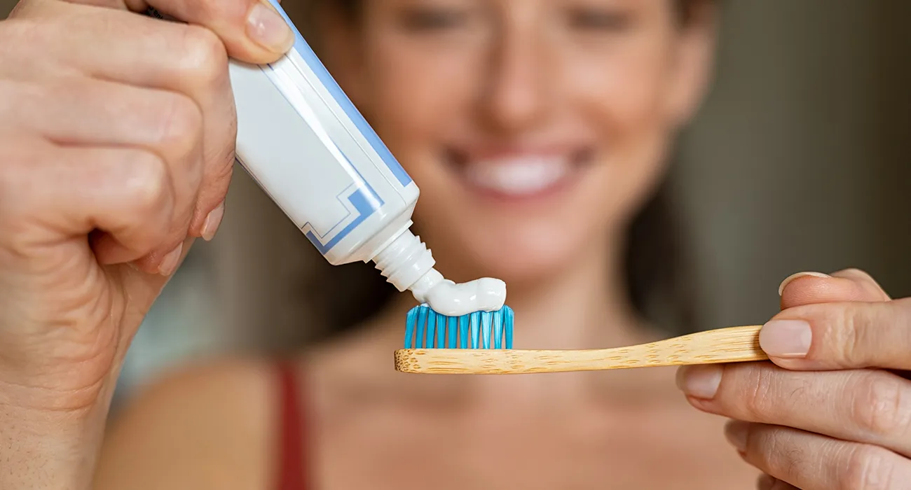 Woman squeezing toothpaste onto a toothbrush