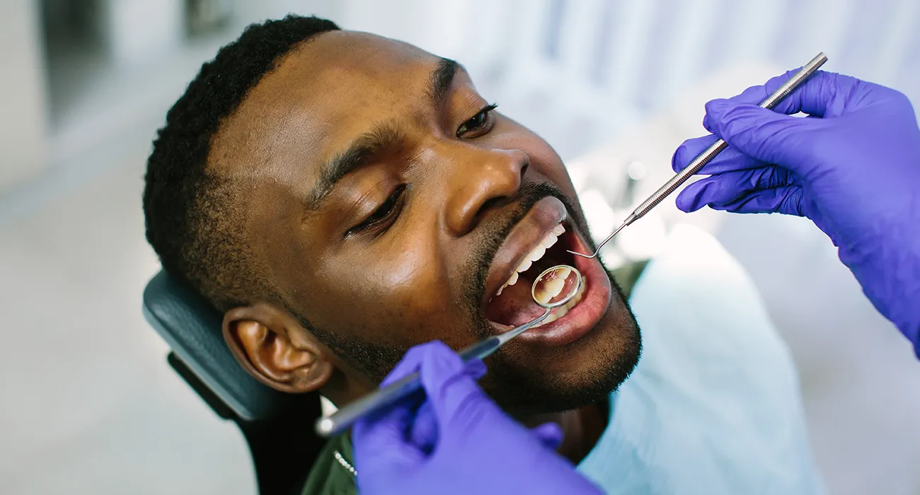 dentist inspecting teeth of man