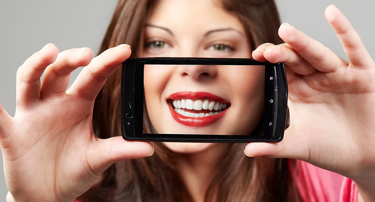 woman holding phone with camera on herself