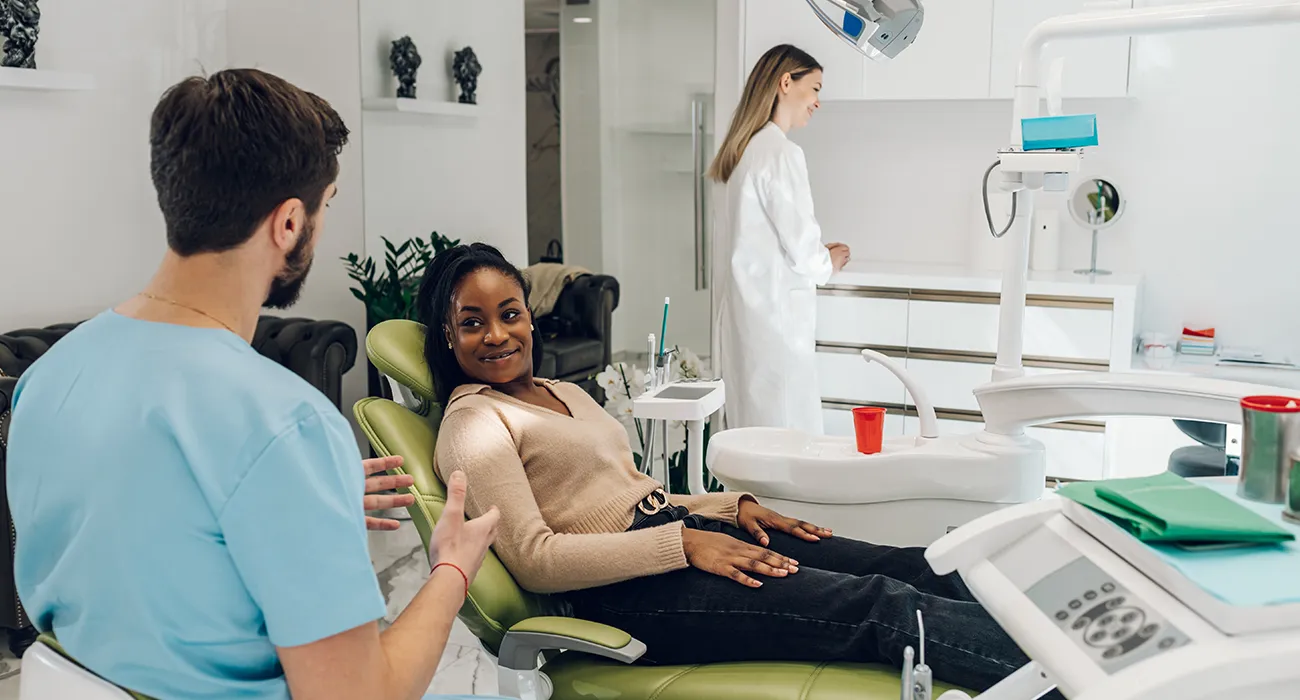 Dentist consulting patient in dental chair