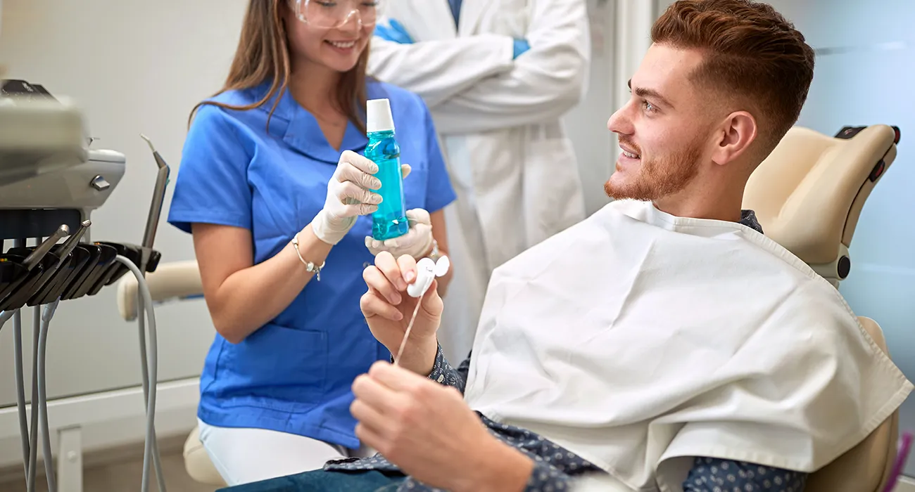 Dentist explaining proper mouthwash use to patient