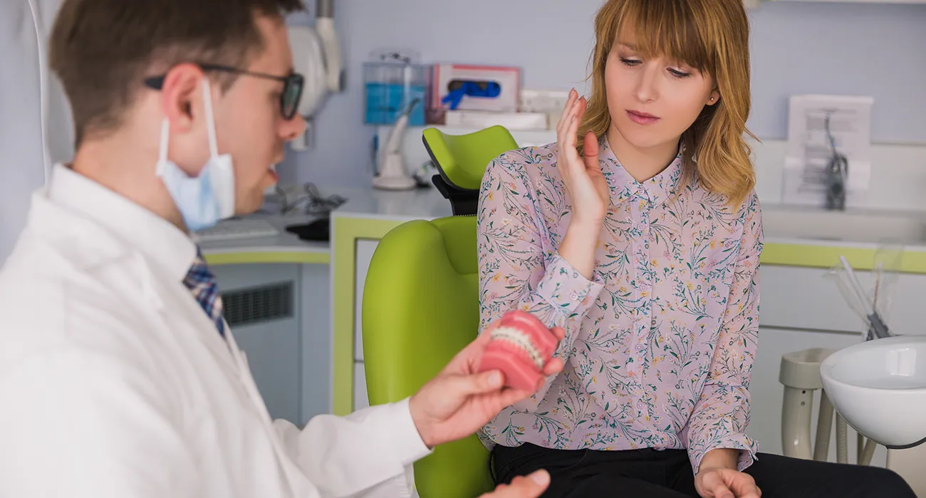 woman consulting with dentist while in pain