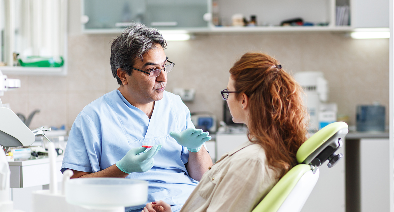 Urgent Dental Care New York dentist talking with patient about their teeth